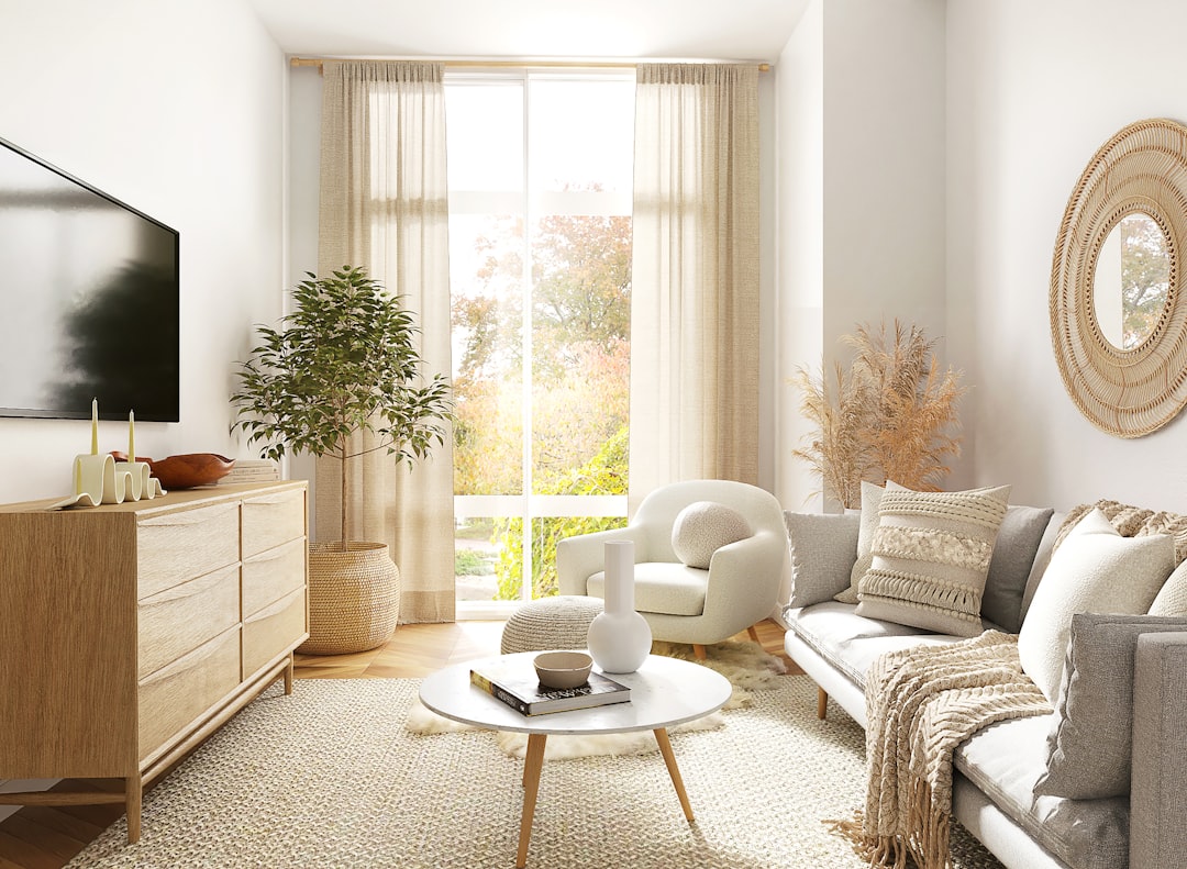 Small neutral living room with a sofa beside a bright window